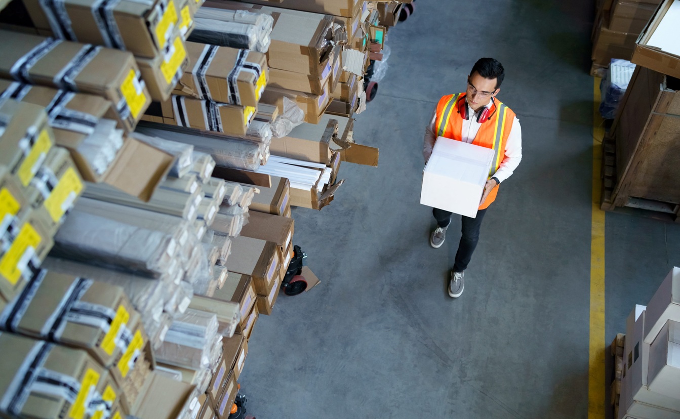 warehouse worker walks with a box