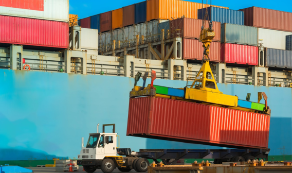 container unloaded from cargo ship and loaded onto truck at port